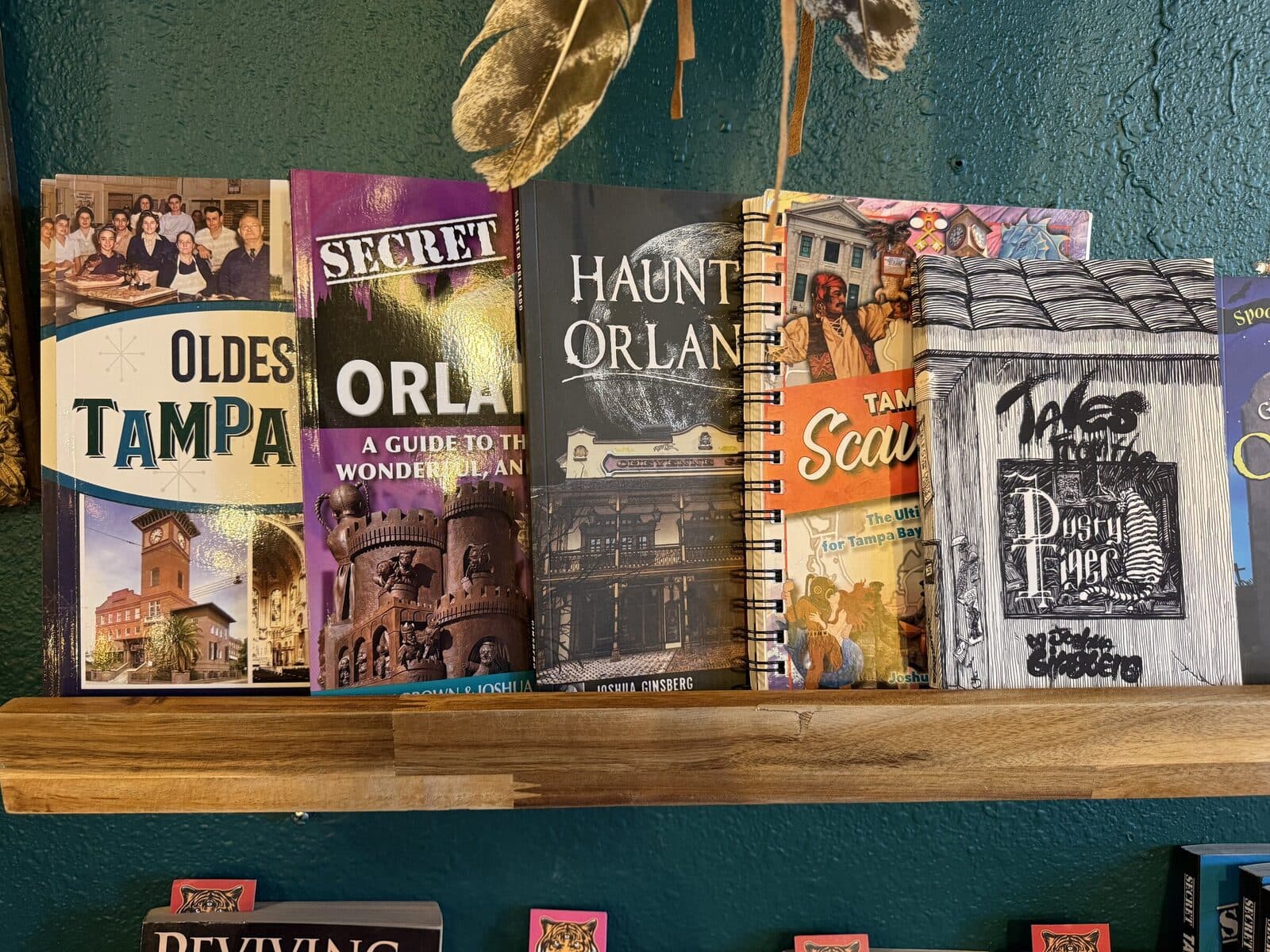 A shelf of local Florida books: Oldest Tampa, Secret Orlando, Haunted Orlando, Tampa Scary, Tales of the Dusty Tiger.