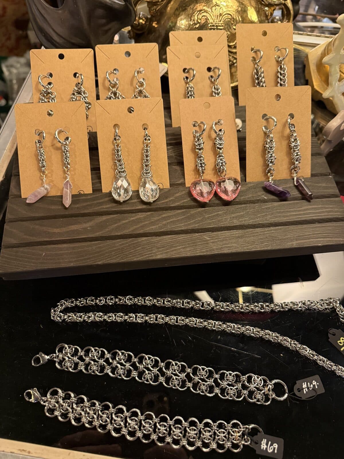 Hand-built chainmaille jewelry on kraft cards: bracelets, dangling earrings with pink quartz and amethyst drops.